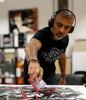 Artistic expression through abstract painting. Confident man in a black shirt, wearing headphones, intently focused on creating an abstract artwork.
