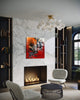 Large abstract artwork on red and white canvas in modern living room with marble wall, fireplace, and chandelier