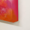 Vibrant abstract painting with warm, fiery colors on a large canvas displayed against a plain white background