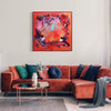 Vibrant abstract canvas artwork titled "Love Is Freedom" depicting a striking composition of bold, earthy colors and dynamic brush strokes, displayed prominently on the wall above a plush, rust-colored sectional sofa in a modern living room setting.