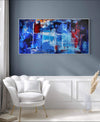 Vibrant abstract landscape artwork | Large canvas painting with bold blue, red, and orange hues | Modern art piece displayed in a minimalist living room setting