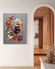 Vibrant abstract canvas painting depicting dynamic, earthy-toned shapes and brushstrokes, displayed prominently in a modern, elegant interior with warm lighting and architectural details.