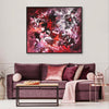 Large abstract painting of a vibrant, textured floral scene in shades of red, purple, and white on a canvas displayed above a plush purple couch in a modern living room setting.