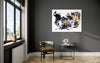 Expansive abstract art | Vibrant black, white, and yellow brushstrokes adorn the large canvas, drawing the eye towards the modern, minimalist room interior.