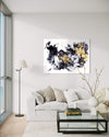 Expressive Abstract Art | Golden Dust 36x48" - Large abstract painting displayed on the wall in a modern living room setting with a gray sofa, floor lamp, and decorative accessories.