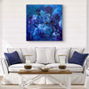 Vibrant abstract canvas art depicting a mesmerizing underwater scene with swirling shades of blue and purple, displayed prominently on the wall above a modern, minimalist living room sofa.