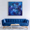 Blue Canvas Art | Down By The Sea 100x100cm

This caption describes the large abstract painting featured in the image, which appears to be a vibrant blue and purple work of art. The painting is displayed on the wall above a blue velvet sofa in a modern, minimalist living room setting.