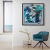 Abstract Blue Canvas Art | Timeless Flow 34x34"
This large abstract canvas artwork features a vibrant blue and green color palette with dynamic brushstrokes, creating a captivating modern art piece for the home or office. The framed square painting is displayed on the wall of a minimalist interior with a gray armchair and wood accent table.