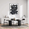 Large modern abstract black and white artwork displayed on a white wall above a minimal dining table with black chairs in a minimalist room setting.