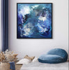 Vibrant blue abstract canvas art featuring dynamic brushstrokes and a mesmerizing mermaid-like motif, displayed prominently on a neutral-toned wall in a cozy living space with plush furnishings.