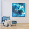 Captivating teal abstract canvas art with dreamlike hues, framed and displayed in modern living space with cozy seating and potted plant.