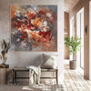 Large abstract painting of fiery colors and expressive brushstrokes, titled "The Furthest Star", displayed in a modern, rustic-style living room setting with neutral tones and natural elements.