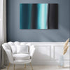 Geometric Painting | Teal Waters 24x36" - Vibrant abstract canvas artwork featuring geometric patterns in shades of teal and turquoise, displayed on a gray wall above a white upholstered chair.