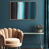 Geometric abstract painting | Teal waters 24x36" on a dark green wall, with a beige velvet armchair and a small table with a floral arrangement in the foreground.