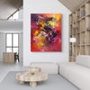 Vibrant abstract painting titled "Summer Memories" by Paresh Nrshinga displayed on the wall of a modern living room with wood accents and minimalist furniture.