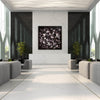 Large abstract painting of dark floral shapes on white wall in modern minimalist interior