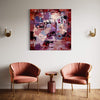 Vibrant Abstract Art | Captured Dream 46x46"
A large, vibrant abstract painting displayed on the wall in a modern living room setting. The painting features bold splashes of red, purple, and blue colors. Two pink velvet armchairs and a wooden side table are positioned in front of the artwork, creating a stylish and cohesive interior design.