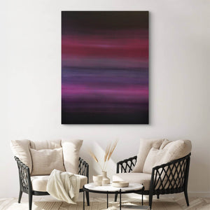 Vibrant geometric abstract art on canvas depicting a dramatic landscape with bold purple, pink, and black hues. The painting is displayed prominently on the wall of a modern living room setting with neutral-toned furniture and decor.