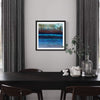 "Blue Moon" Signed Edition Abstract Art Print

This description captures the essential elements of the image, including the product (a signed edition abstract art print titled "Blue Moon"), its placement on the wall, and the surrounding decor such as the curtains, table, and decorative items. The description is relevant, concise, and focuses on the key features of the product shown in the image.