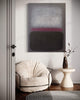 Minimalist abstract painting with vibrant colors on the wall, complemented by a cozy white chair and a decorative vase on a side table, creating a serene and modern interior design.