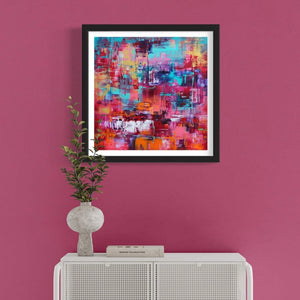 Vibrant abstract art print titled "Magical Kingdom" showcased on a pink wall, surrounded by a modern white furniture piece and a decorative plant vase, creating a stylish and contemporary home decor setting.