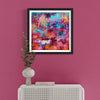 Vibrant abstract art print titled "Magical Kingdom" showcased on a pink wall, surrounded by a modern white furniture piece and a decorative plant vase, creating a stylish and contemporary home decor setting.