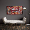Large abstract landscape artwork titled "Memory Lane II" displayed on a grey wall above a white modern sofa. The painting features vibrant red, yellow, and brown tones creating a bold, contemporary abstract design. The artwork is surrounded by a simple minimalist furniture arrangement, including a floor lamp and stools, creating a stylish and modern interior setting.