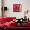 "Vibrant Abstract Art Print" - Framed colorful abstract artwork displayed on the wall above a plush red sofa, complemented by a modern lamp and stylish decor in a cozy living room setting.
