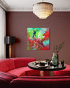 Vibrant abstract painting on wall, large red sofa, ornate ceiling light fixture, round coffee table with decorative items in modern and stylish living room interior.