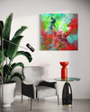 Vibrant abstract painting on canvas displayed in a modern home interior with a grey armchair, a red vase, and a potted plant.