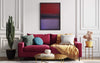 Bold abstract painting on the wall depicting vibrant red and purple geometric shapes. Red plush sofa with decorative pillows, and a gold-tone coffee table in a modern, stylish living room setting.