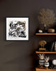Framed abstract art print "Dancing Shadows II" displayed on dark wall with wooden shelves showcasing decorative coral and ceramic pieces