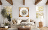 Large abstract square artwork titled "Light Falls Away" showcasing a textured, mixed media composition in a modern, rustic living room setting with natural wood beams and windows.