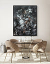Framed abstract artwork with striking monochrome palette and organic shapes, creating a bold focal point over a minimalist dining table setting.