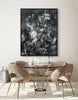 Framed abstract artwork with striking monochrome palette and organic shapes, creating a bold focal point over a minimalist dining table setting.
