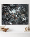 Large abstract painting with dynamic brushstrokes and contrasting colors, featuring a blend of black, white, and earthy tones, showcased on a wall with simple wooden decor.
