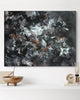 Large abstract painting with dynamic brushstrokes and contrasting colors, featuring a blend of black, white, and earthy tones, showcased on a wall with simple wooden decor.