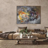 Large modern abstract painting with earthy color tones depicting a vibrant floral composition on a large canvas displayed in a living room setting with a cozy seating area and natural decor elements.