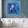 Large abstract blue painting entitled "Emotions" displayed on a gray wall in a modern living room setting, with a white armchair and decorative accents in the foreground.