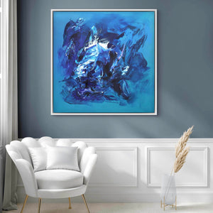 Large abstract blue painting entitled "Emotions" displayed on a gray wall in a modern living room setting, with a white armchair and decorative accents in the foreground.