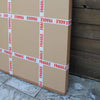 Large fragile cardboard boxes stacked against a concrete wall and floor