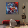 Vibrant abstract painting | Multicolour abstract artwork on canvas with bold strokes and harmonious blend of colors in the foreground, displayed on a grey wall with wooden floor and modern furniture in the interior setting.