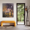 Large abstract landscape painting featuring earthy tones and bold brushstrokes, displayed on the wall of a modern interior with a scenic forest view through a glass door.