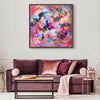 Large Abstract Canvas Art | Vibrant Hues 100x100cm
A large, colorful abstract painting with bold, energetic brushstrokes in a variety of warm and cool tones. The artwork is displayed on a white wall above a cozy, plum-colored sofa, creating a modern and sophisticated living room setting.