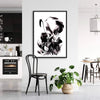Abstract black and white art piece depicting fluid motion, framed and displayed in modern living space with kitchen and dining area.
