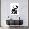 Modern abstract artwork with dynamic black and white brushstrokes displayed on a wall in a stylish home interior setting with a sideboard and decorative objects.
