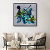 Framed abstract artwork depicting vibrant brushstrokes and geometric shapes in shades of blue, green, and brown. The artwork is displayed on a white wall, complemented by a seating area with neutral-toned furniture.