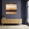 Large abstract painting with textured gold and brown tones displayed on a dark gray wall above a wooden sideboard in a modern interior setting.