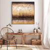 Textured abstract painting featuring gold and earthy tones, showcased in a modern home setting with wooden furniture and decor.
