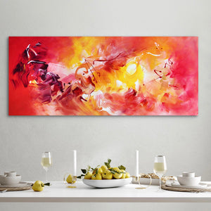 Vibrant abstract painting "Quiet Flame II" with bold brushstrokes in fiery reds, oranges, and yellows, displayed on the wall above a dining table setting with fresh pears and dishware.